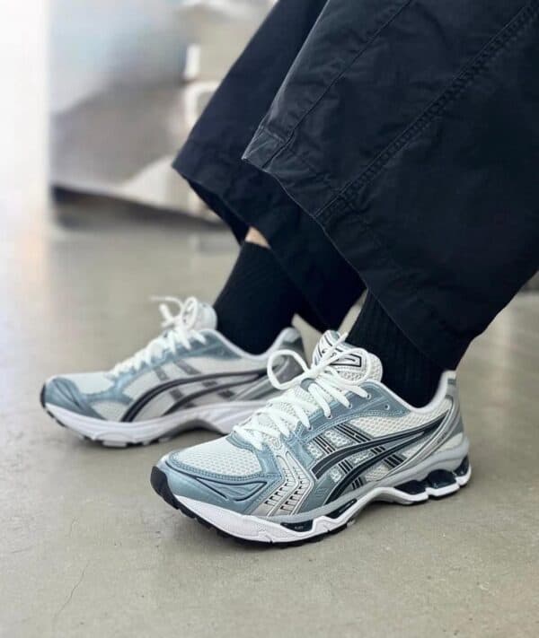 ASICS Gel-Kayano 14 running shoes in white and grey, designed for comfort and support.