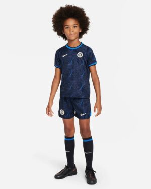 Young girl in Chelsea away football kit 2023/24, navy blue with team logo and Nike branding.