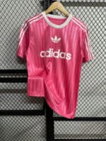 Pink Adidas sports shirt with white logo and stripes.