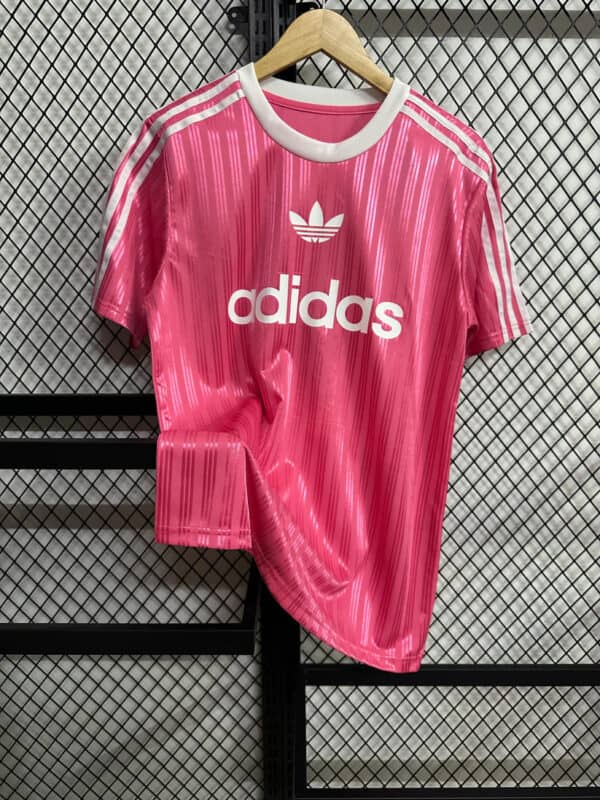Pink Adidas sports shirt with white logo and stripes.