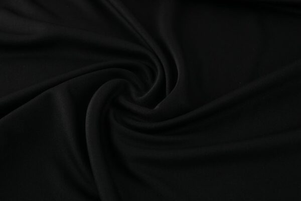 Black Nike Dri-Fit tracksuit fabric, smooth and lightweight for athletic comfort.