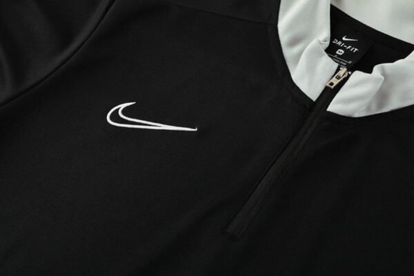 Nike Dri-Fit black tracksuit top with white logo and zip closure.