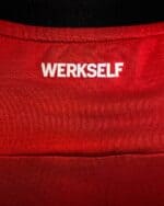 Bayer Leverkusen 2024/25 home football jersey with WERKSELF logo, red color, and breathable fabric.