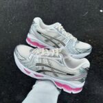 ASICS GEL-Kayano 14 running shoes in cream and pink with metallic accents.