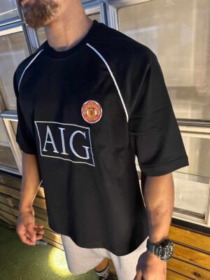 Man United black classic football shirt with club crest and AIG sponsor logo.