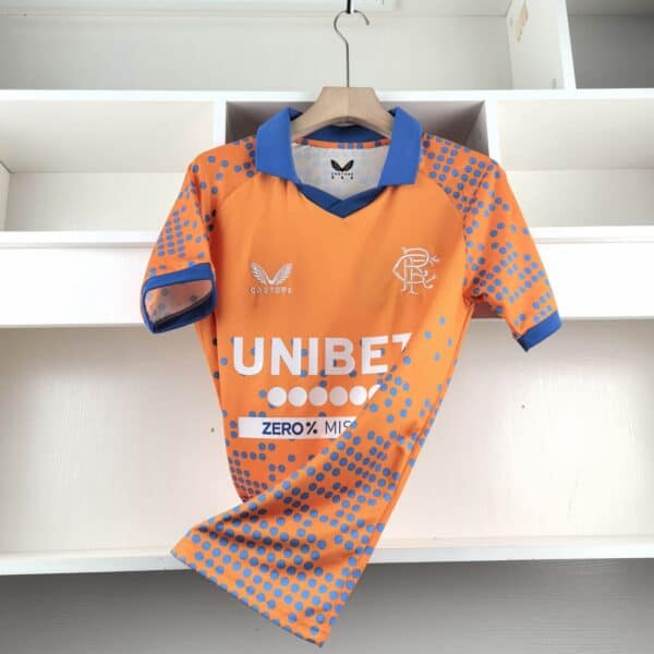 Official Rangers FC third football jersey 2024/25 season. Bright orange with blue accents and team l.