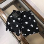 Black swim shorts with DG logo pattern, perfect for beach and pool.