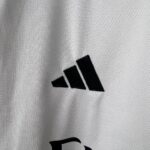 Adidas logo on white athletic jersey, high-quality sportswear for athletes.