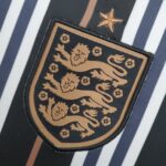 England football team badge in black and white with gold accents and star.