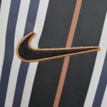 Nike Swoosh logo embroidered on black and white striped football jersey.