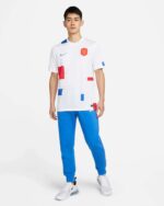 Football jersey with NetherLan 2022 design, white with red and blue accents, for away matches.