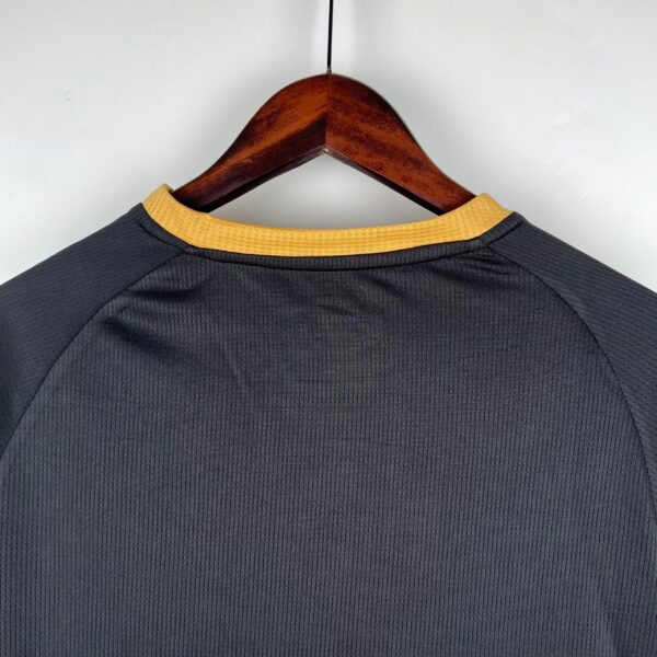 Authentic football jersey featuring black material and yellow neckline for sports enthusiasts.