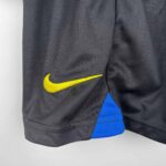 Nike yellow swoosh logo on black kids' football jersey.