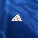 Close-up of Adidas logo on Italy kids' 2023/24 home football kit fabric.