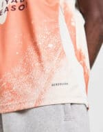 Athletic orange and white sports shirt with "AEROREADY" logo, ideal for training and running.