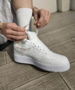 Louis Vuitton x Nike Air Force 1 Low white sneakers with embossed monogram design.
