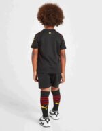 Kids Manchester City Away Football Kit 2022/23, black jersey and shorts with team logo.