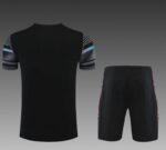 Training set for Manchester City 2022/23 season, including a black jersey with colorful sleeve accen.