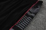 Man City 2022/23 training kit with black and grey design, featuring club logo and red accents.