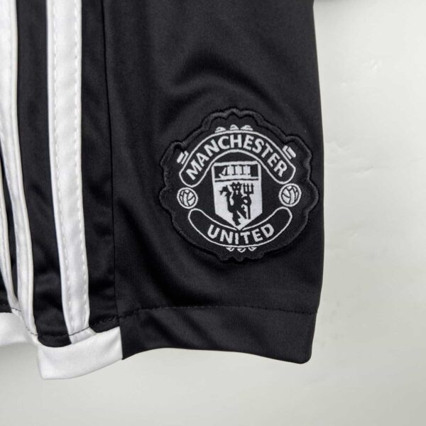 Manchester United kids away kit 2023/24 with club badge detail.