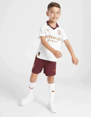 Kids football kit Manchester City away 2023/24, featuring jersey, shorts, and socks for young fans.