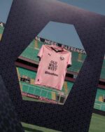 Palermo F.C. home jersey 2024/25 with pink color and team logo, displayed in stadium setting.