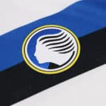 Atalanta away football jersey 2024/25 with team logo and bold blue, black, and white design.