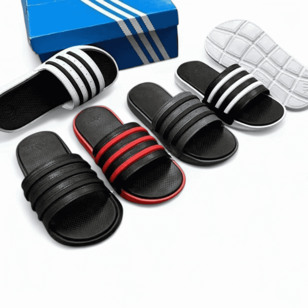 Comfortable black and red slide sandals with triple stripe design and cushioned grip sole. Perfect f.