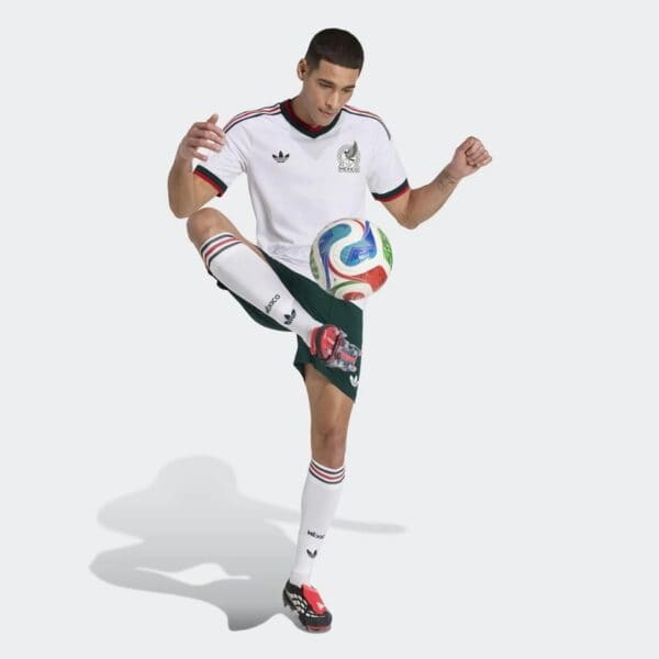 Male football player in Mexico away jersey kicking a ball, World Cup 2026.