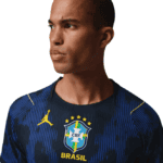 Portrait of a man wearing a dark blue Brazil national football team jersey with the CBF crest, looking to the left.