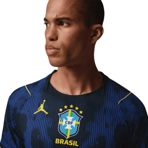 Portrait of a man wearing a dark blue Brazil national football team jersey with the CBF crest, looking to the left.