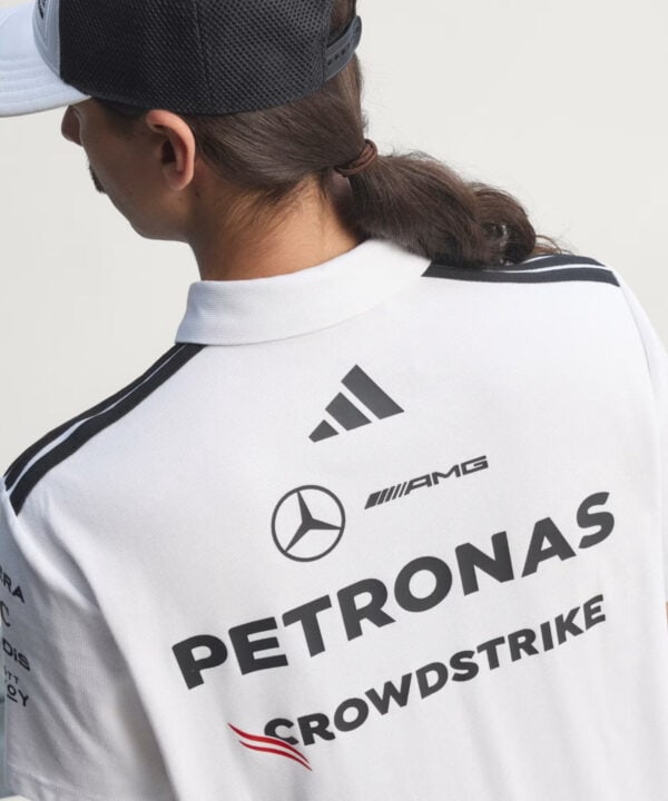 Back of a person wearing a white racing polo with PETRONAS, AMG and Mercedes logos viewed from behind
