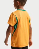 Back view of a child wearing an orange sports jersey with green side panels.