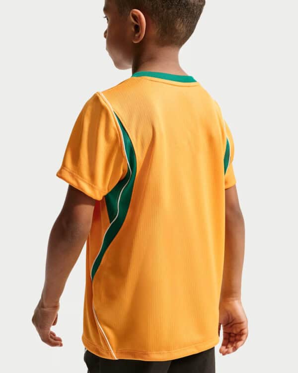 Back view of a child wearing an orange sports jersey with green side panels.