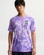 Purple camouflage soccer jersey with Korea crest and Nike swoosh worn by a male model; front view shows design details.