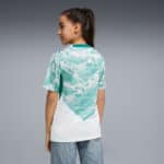 Back view of a person wearing a turquoise and white tie-dye sports jersey with a diagonal white panel, paired with light blue jeans.