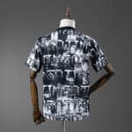 Back view of a short-sleeve black-and-white abstract print T-shirt on a dress form.