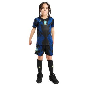 Young child wearing a blue and black Brazil national team soccer kit with matching shorts and black socks and cleats.