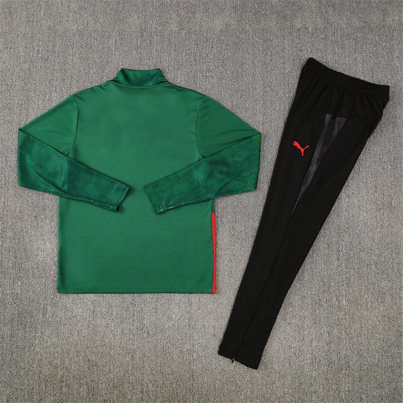 00d99919-7092-4f82-b33f-3f507d097573 | UAE SPORT STORE Green long-sleeve athletic shirt with textured sleeves and a red side stripe, paired with black jogger pants featuring a red Puma logo, laid flat on a gray surface.