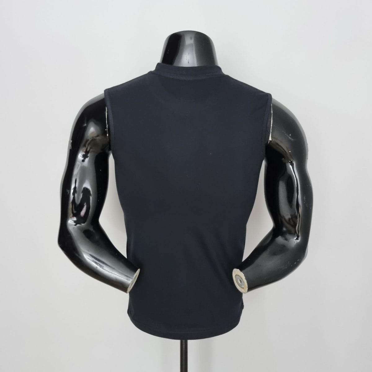 Back view of a glossy black mannequin torso wearing a sleeveless dark top, mounted on a stand.