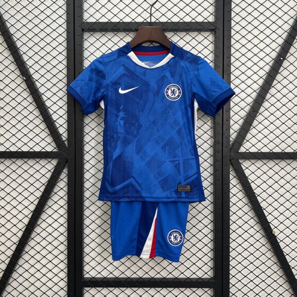 Chelsea football jersey on a wooden hanger against a metal grid background, featuring a white Nike swoosh and Chelsea crest on a blue kit with red/white trim.