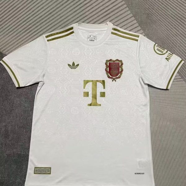 White soccer jersey with gold accents, featuring an Adidas logo, a club crest on the left chest, and a large gold sponsor logo centered on the front; gold stripes on the shoulders and sleeve cuffs.