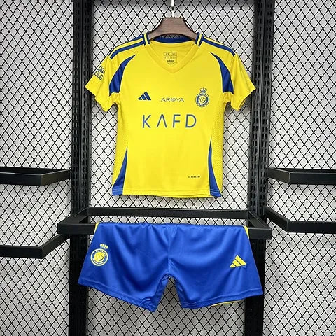 01a779_65eb682260164ae8b192e5e2bad208d3_mv2 | UAE SPORT STORE Yellow soccer jersey with blue accents on a hanger above royal blue shorts; jersey shows club crest, Adidas logo, and sponsor text 'KAFD'.