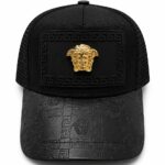 Black baseball cap with a gold Medusa emblem on the front and a Greek key pattern along the patch and brim.