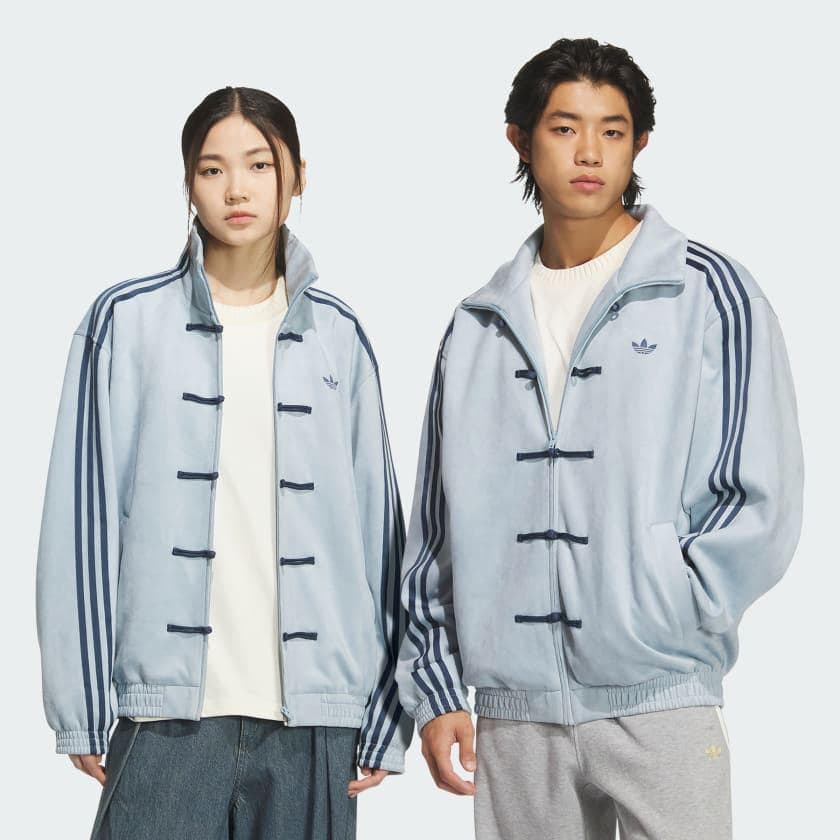 0293a7e7-7d14-46a8-a256-d82679840f31 | UAE SPORT STORE Two young models wearing light blue duffle jackets with dark blue toggles and stripes, standing side by side.