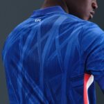 Back view of a blue soccer jersey with an abstract geometric pattern and a small 'CFC' logo near the collar.