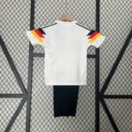 03f11bb0 | UAE SPORT STORE White short-sleeve shirt on a hanger, back view, with colorful angled shoulder accents in yellow, red, and black. Black pants hang below.