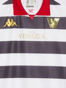 Close-up of Venezia FC soccer jersey showing the gold Kappa logo on the left, gold club crest on the right, a red collar, and 'VENEZIA' in gold lettering.