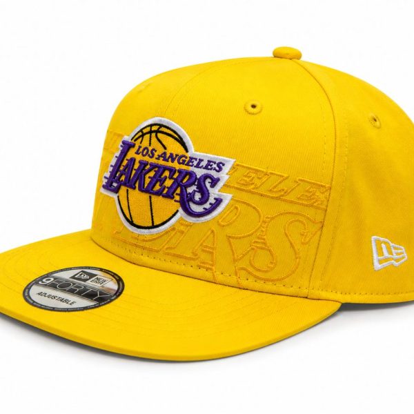 Yellow Los Angeles Lakers baseball cap with a purple Lakers logo embroidered on the front and an adjustable strap. (New Era 9FORTY) Readily identifiable team merchandise.