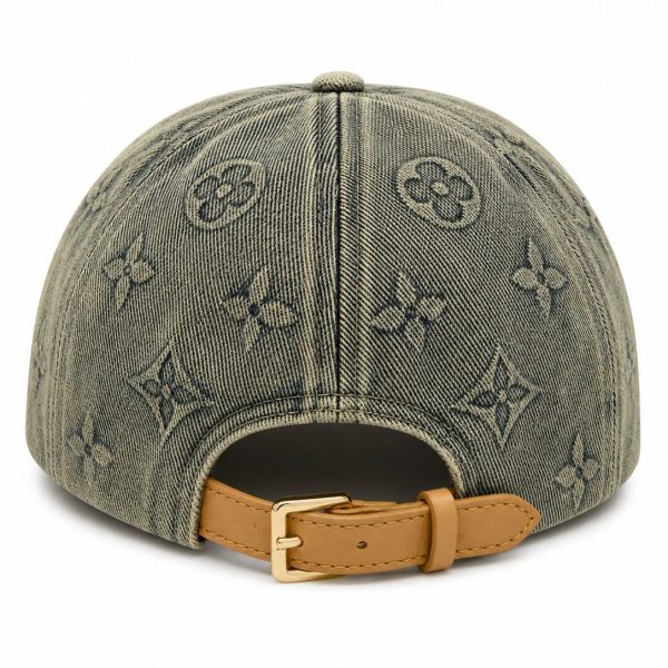 Back view of a denim baseball cap with an all-over monogram print and a tan leather strap with a gold buckle closure.